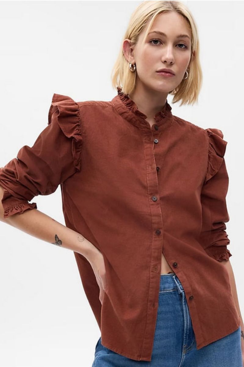 Model wears brown corduroy top with ruffle sleeves by Gap. 