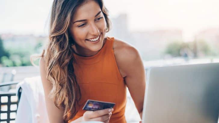 Woman shops Farfetch sale on her laptop.