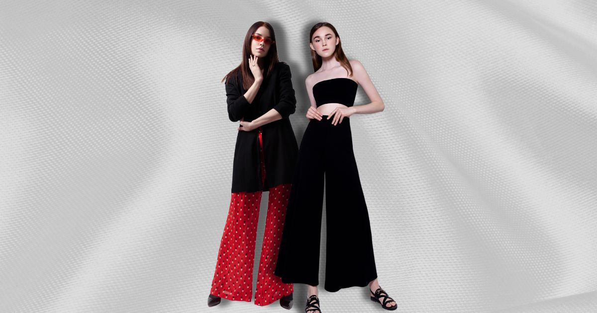 Two women wearing wide-legged pants against a textured background.