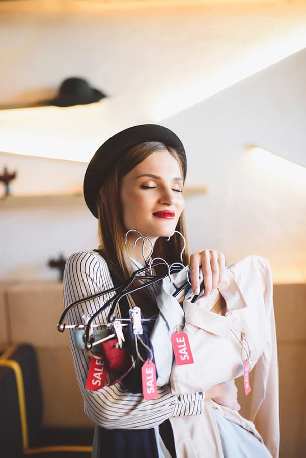 Holiday shopping: 9 ways to save $1,000+ 1 Young woman shopping clothes on sale
