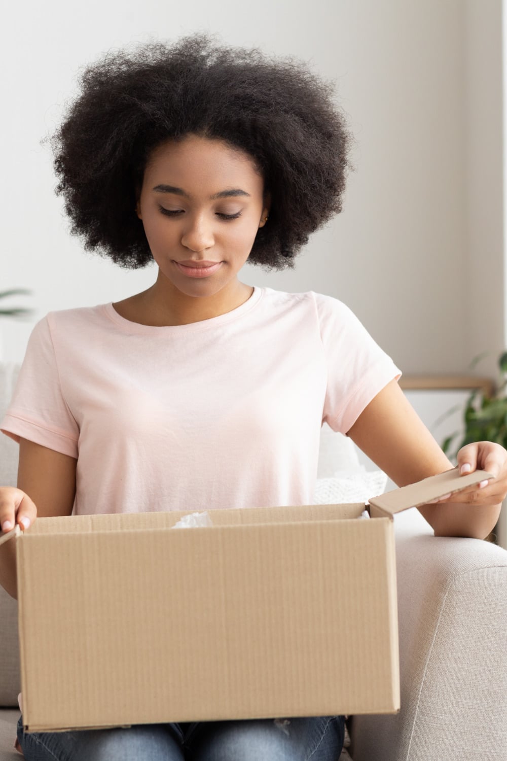 Woman opens box from online order, thankful she bought from a store that offers free shipping and returns. 