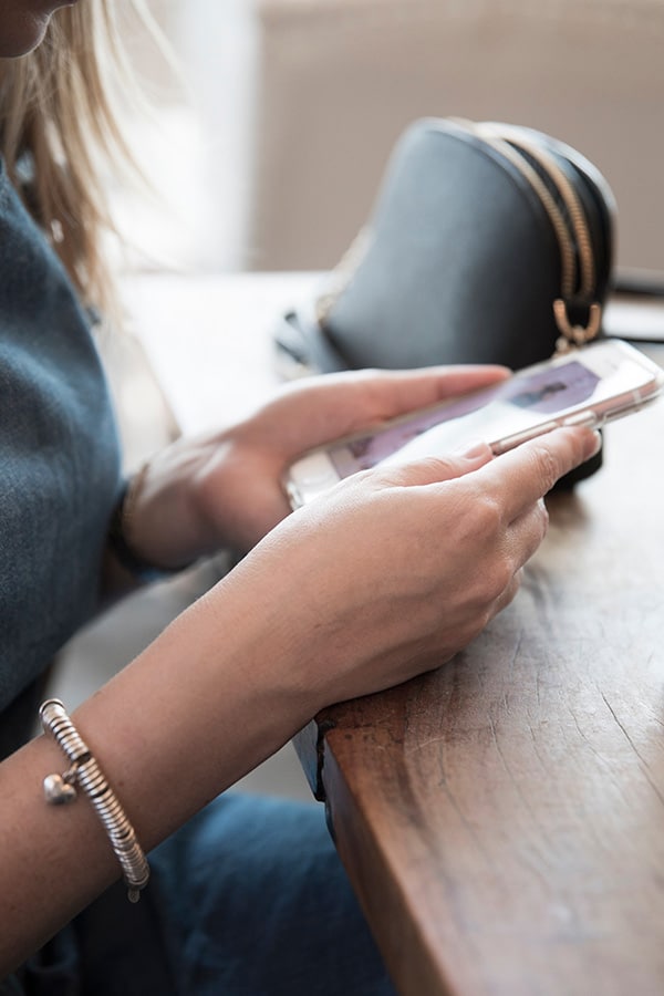 Girl shops for clothes on her phone during shopstreaming event.