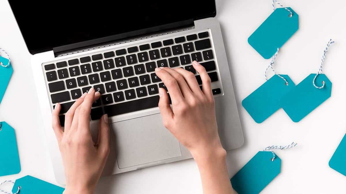 Hands on laptop to represent price comparison shopping.