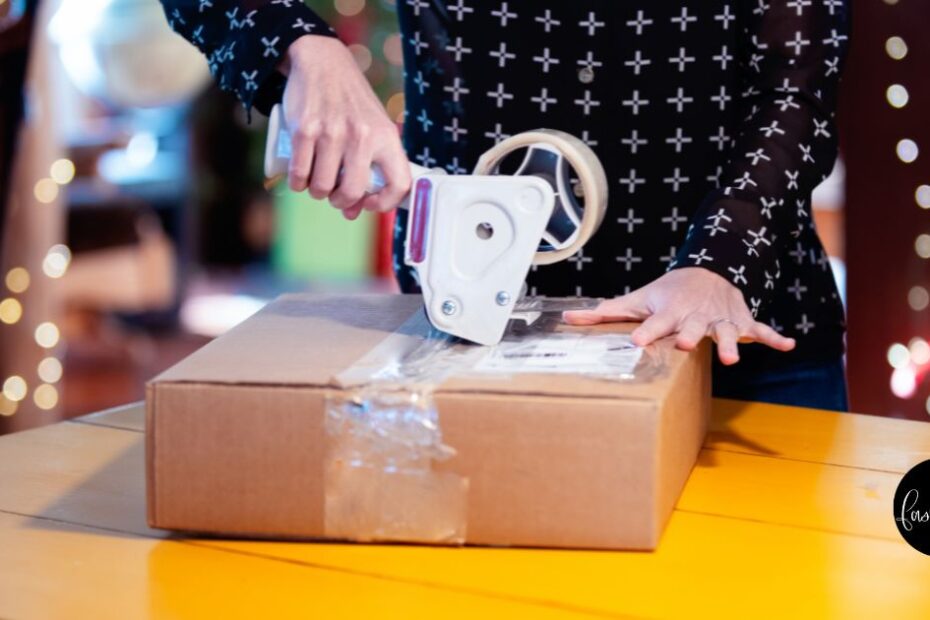 close up of someone putting mail tape on a package