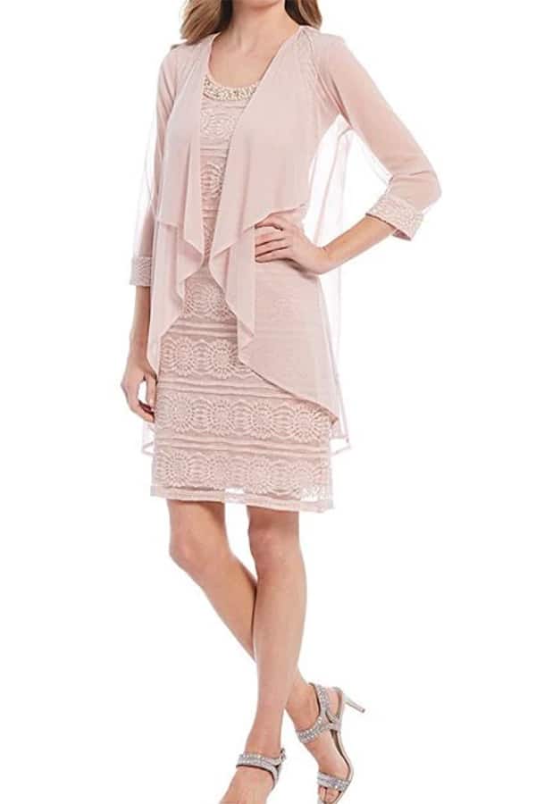 Model wearing two-piece jacket dress, formal enough to be a wedding guest dress.