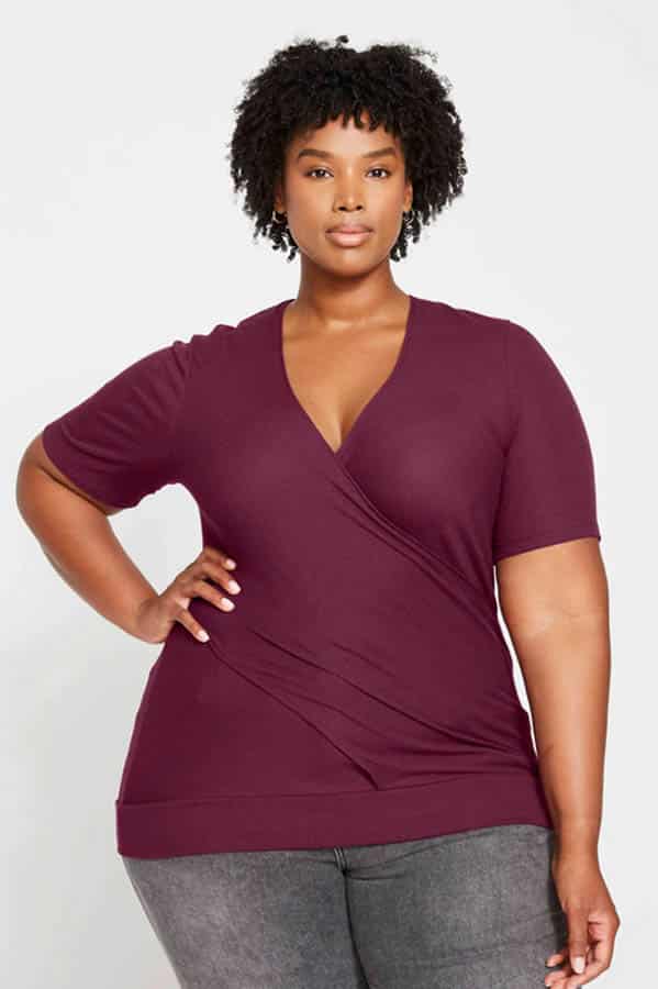 Plus-sized model wears ribbed wrap top.