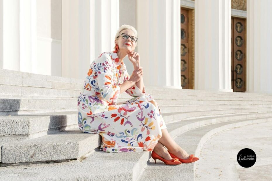 Old woman in floral dress sitting on steps