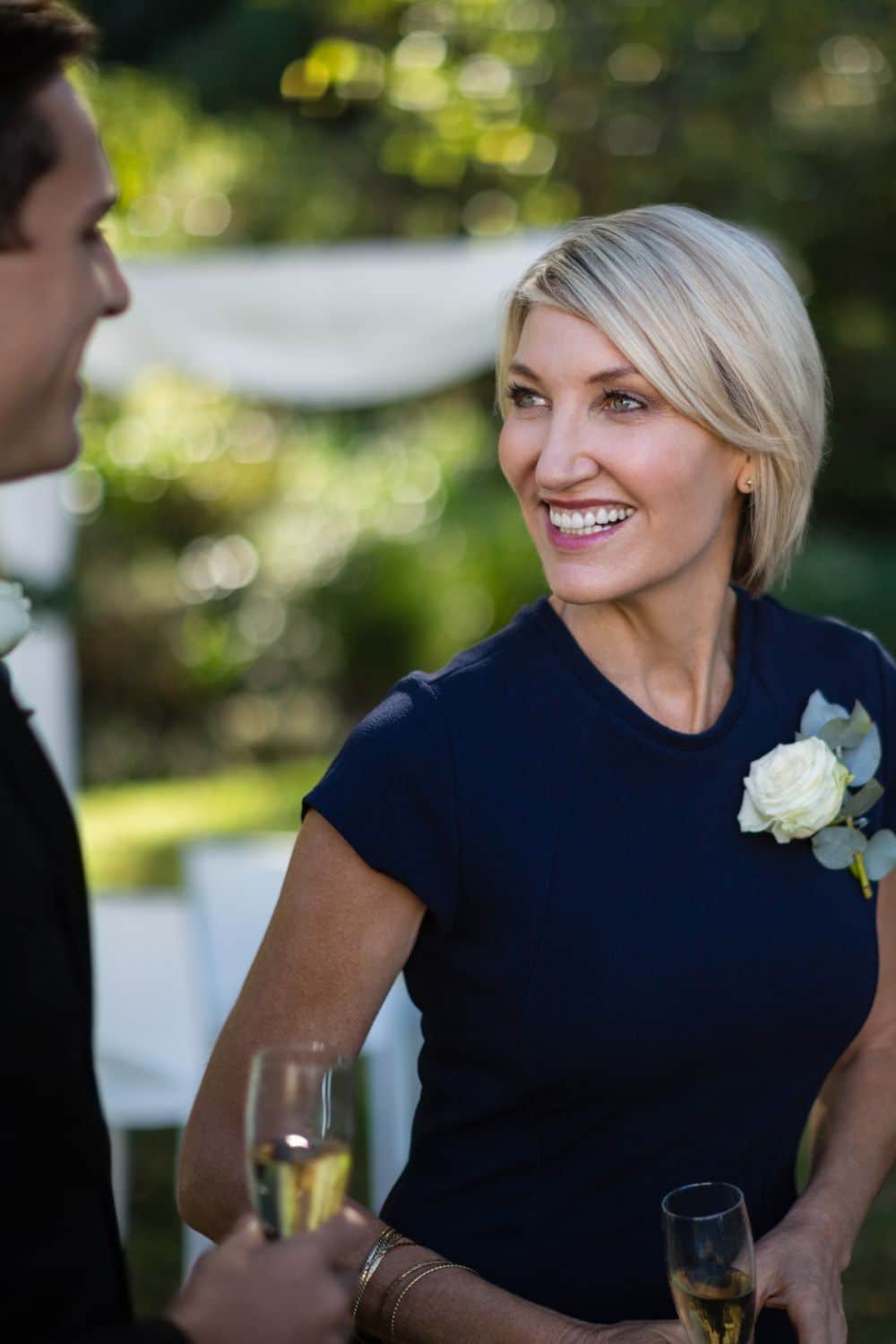 Smiling wedding guest to represent what to wear to a fall wedding.