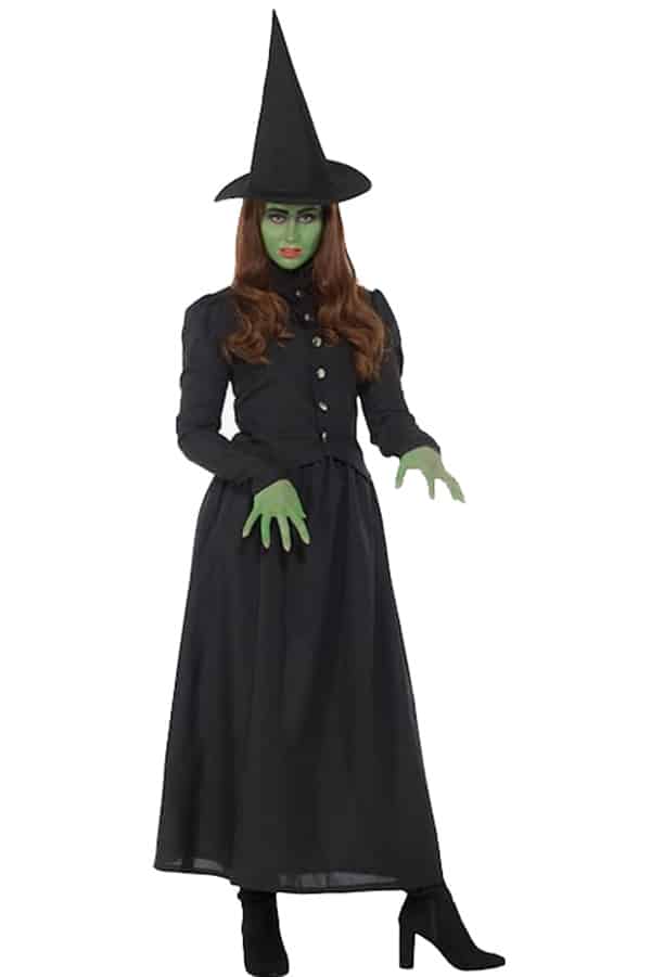 Woman wearing witch costume with green makeup.