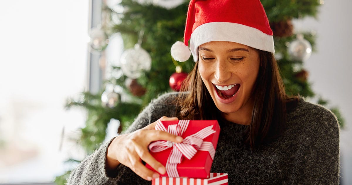 Woman opens holiday gift.