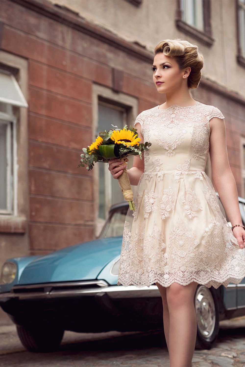 The best money saving wedding tips, according to experts 2 Woman walks on street wearing retro wedding dress and holding flowers.