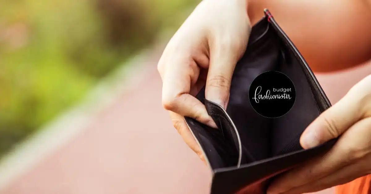 Person holding open an empty wallet outside.